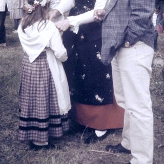 Mid-20th-century outdoor event with formal attire and floral decorations.
