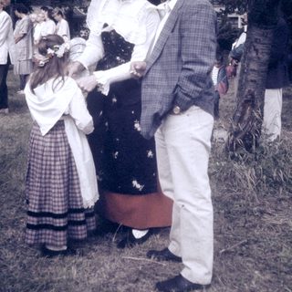 Mid-20th-century outdoor event with formal attire and floral decorations.