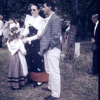 Mid-20th-century outdoor event with formal attire and floral decorations.