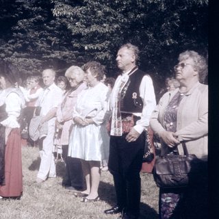 Group of people in traditional and casual attire outdoors.