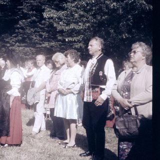 Group of people in traditional and casual attire outdoors.