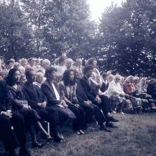 Group of people seated outdoors at an event.