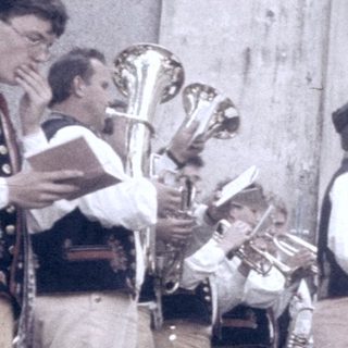 Traditional folk group performing outdoors in cultural attire.