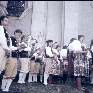 Traditional folk group performing outdoors in cultural attire.