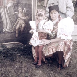 Family posing with religious mural outside.