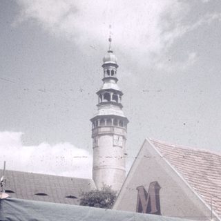 Street market stall with musical performance near historic tower.