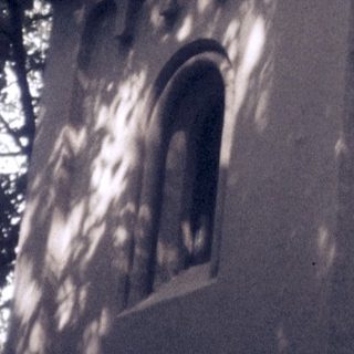 Small stone bell tower with arched windows.