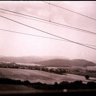 Rural landscape with rolling hills and power lines.