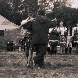 Traditional folk dance performance outdoors in historical attire.