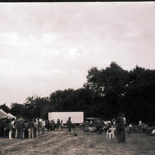 Outdoor gathering with tents and open-air event.