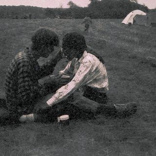 Two people sitting outdoors, engaged in conversation.