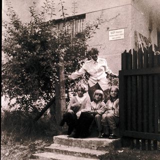 Family posing on outdoor stairs near building.