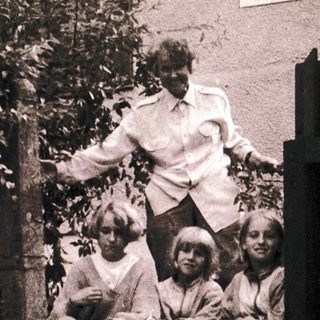 Family posing on outdoor stairs near building.