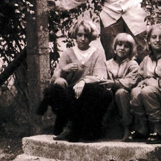 Family posing on outdoor stairs near building.