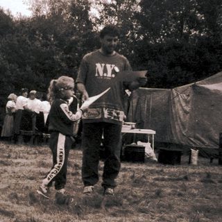 People camping outdoors near tents.