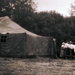People camping outdoors near tents.