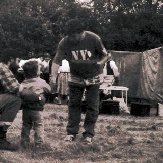 People camping outdoors in tents with children.