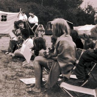 Medieval reenactment scene with performers and audience.