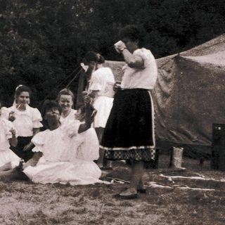 Group playing traditional game outdoors in tents.