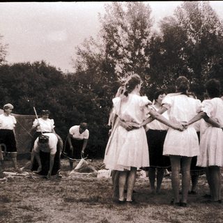 Group of people in outdoor camp setting, engaging in activities.