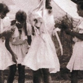 Vintage outdoor gathering with tents and people.