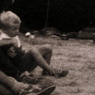 Group of people sewing outdoors near tents.