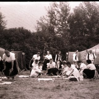 Group of people engaged in traditional rope-making outdoors.