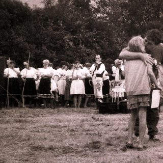 Medieval reenactment gathering with tents and participants.
