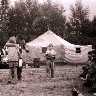 Medieval reenactment gathering with tents and participants.