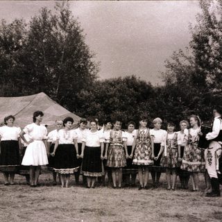 Group performing traditional folk song outdoors.