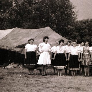 Group performing traditional folk song outdoors.