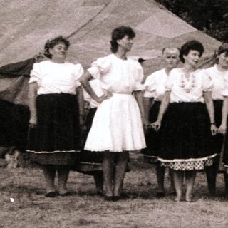 Group performing traditional folk song outdoors.