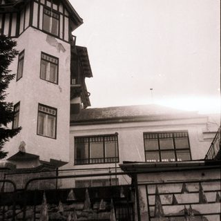 Chalet-style building with stone foundation, multiple windows.