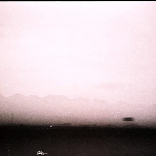 Misty landscape with distant, faint mountain range.