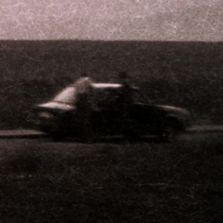 Blurred car driving past mountain range.