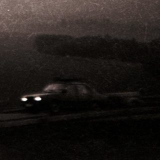 Blurred highway scene with distant snow-covered mountains.