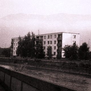 Urban residential buildings near railway tracks.
