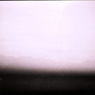 Foggy horizon with indistinct distant landforms.