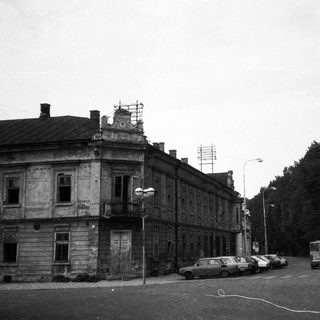 Agrarian town street with old buildings and parked cars.