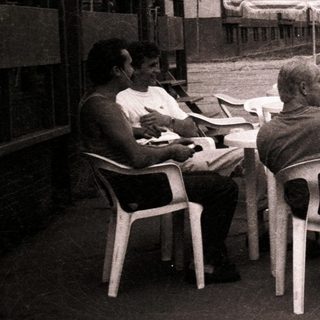 People sitting outdoors near mountains in urban café setting.