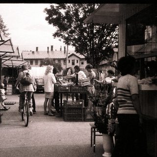 Farmers market with people shopping outdoors.