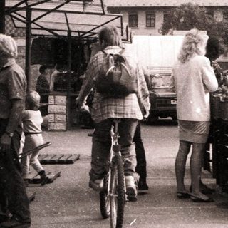 Farmers market with people shopping outdoors.