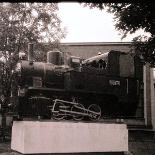 Steam locomotive displayed on pedestal.