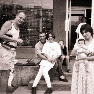 Family gathering outdoors in casual summer attire.