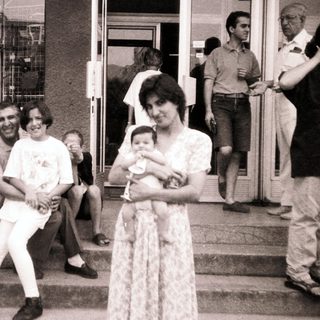 Family gathering outdoors in casual summer attire.