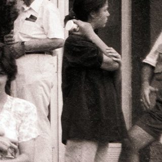 Family gathering outside a building in summer attire.