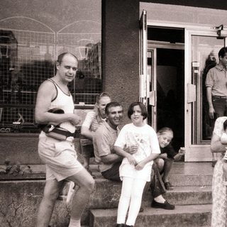 Family gathering outside a building in summer attire.