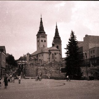 Historic town square with church and pedestrians.