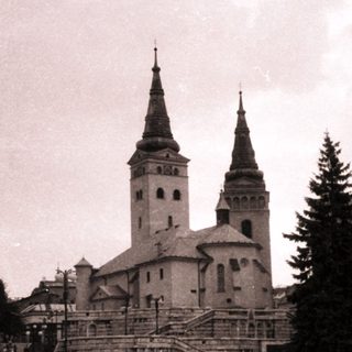 Historic town square with church and pedestrians.