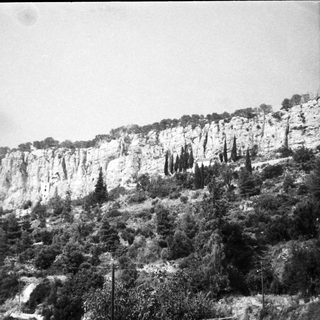 Steep limestone cliffs with sparse vegetation.